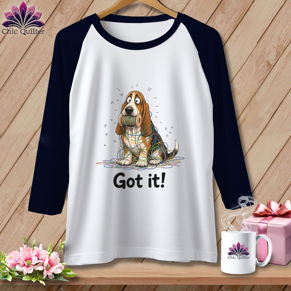 Raglan tee with a Basset Hound entangled in colorful yarn and the text "Got it!".