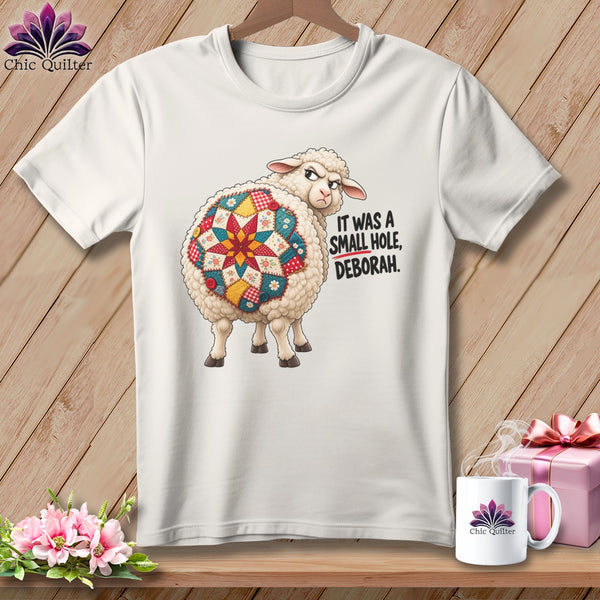 White t-shirt with quilted sheep graphic and text "IT WAS A SMALL HOLE, DEBORAH."