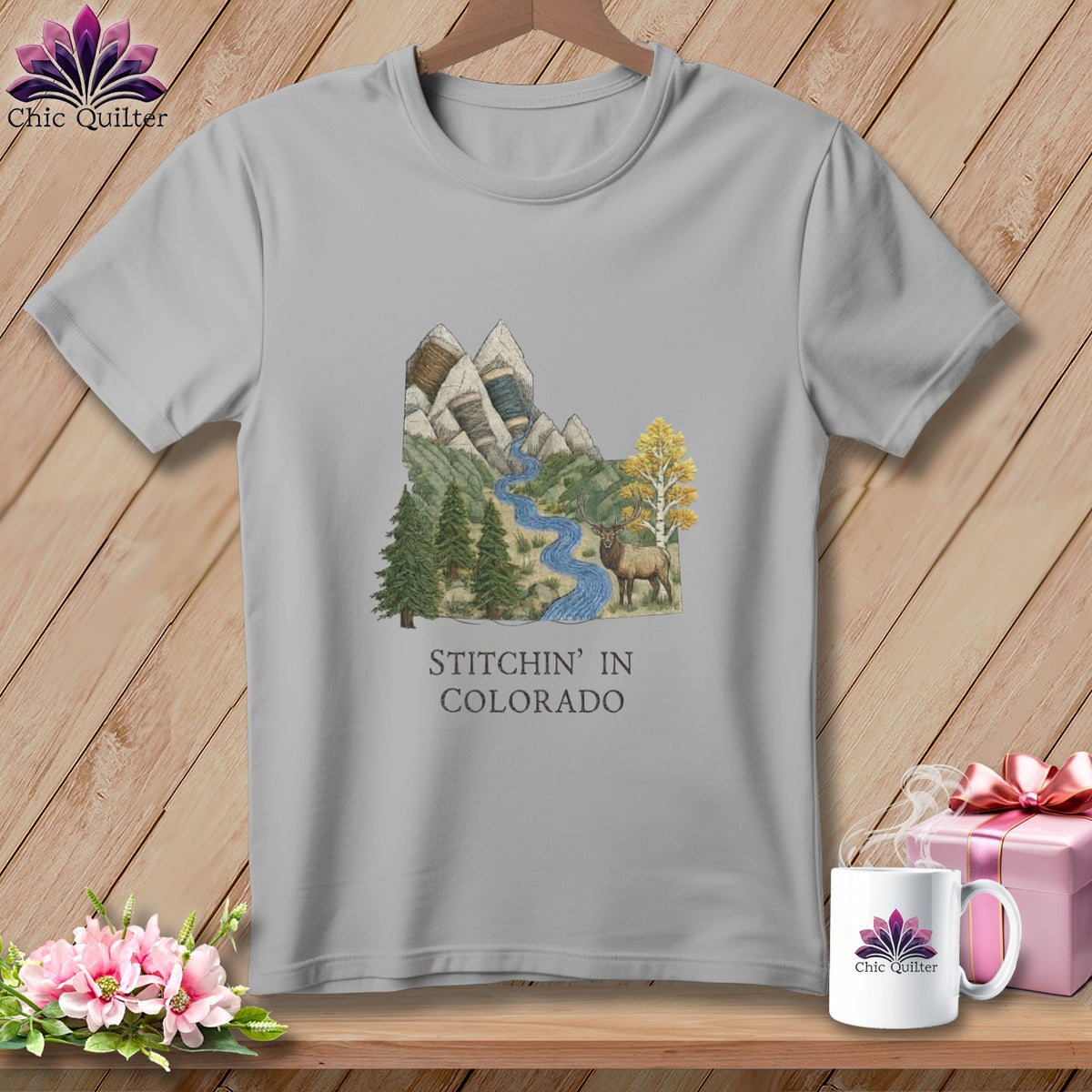 T-shirt with mountains, river, elk, and "Stitchin' in Colorado" text.