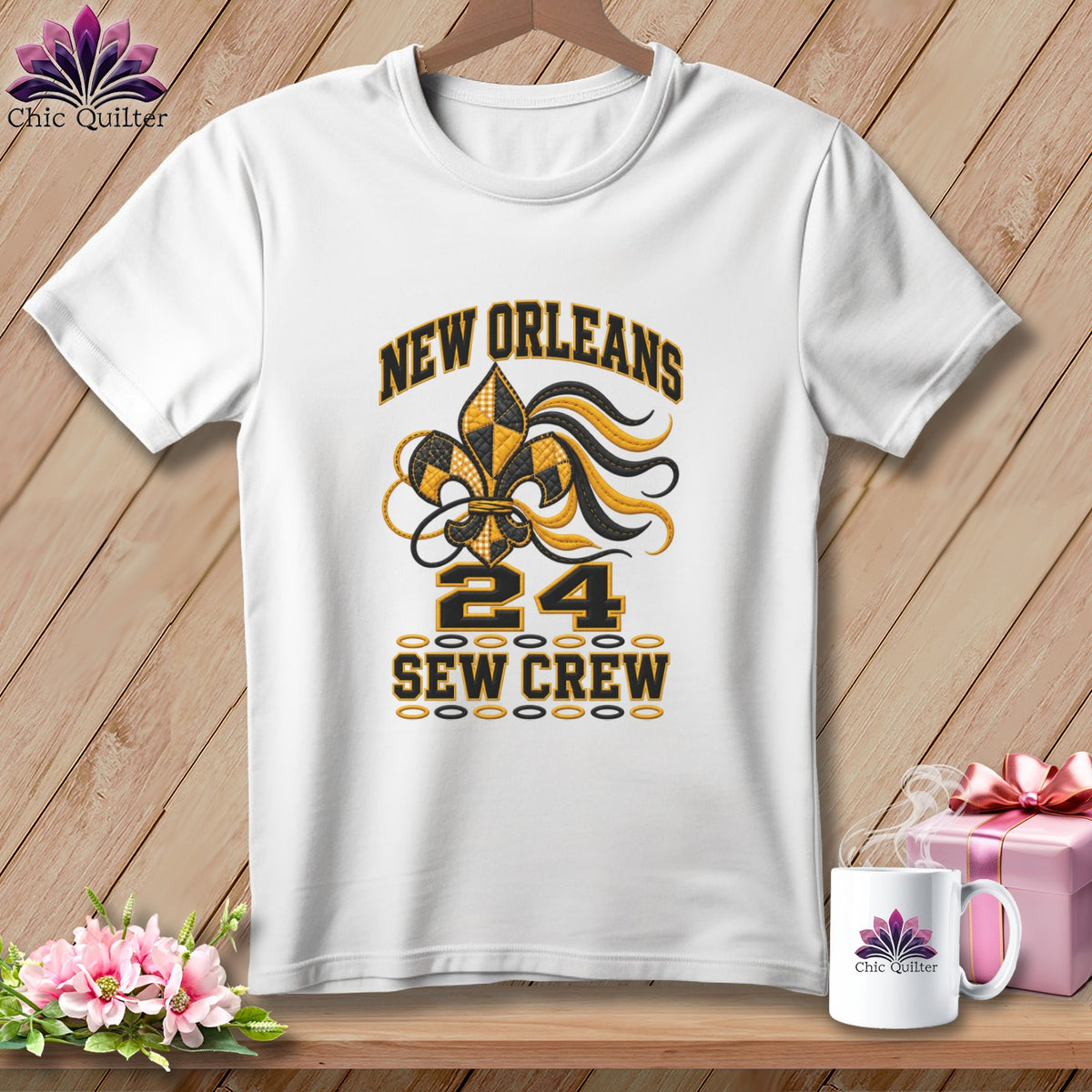A white t-shirt hanging on a wooden background, featuring a New Orleans sew crew design with a fleur-de-lis motif and the number 24.