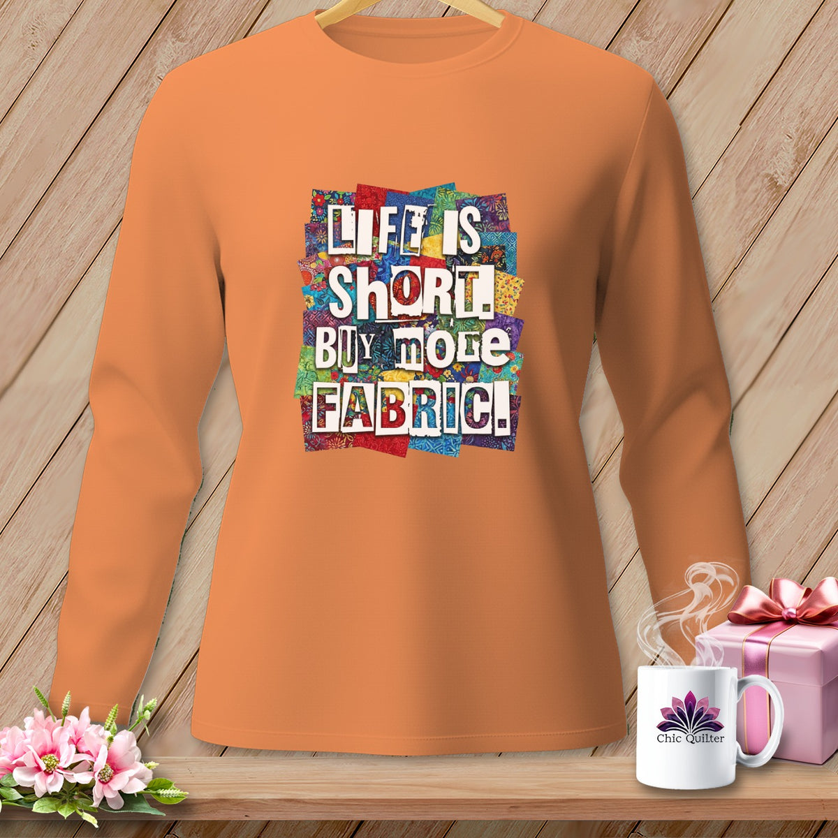 Orange long-sleeve shirt with "LIFE IS SHORT. BUY MORE FABRIC." text and patchwork design.