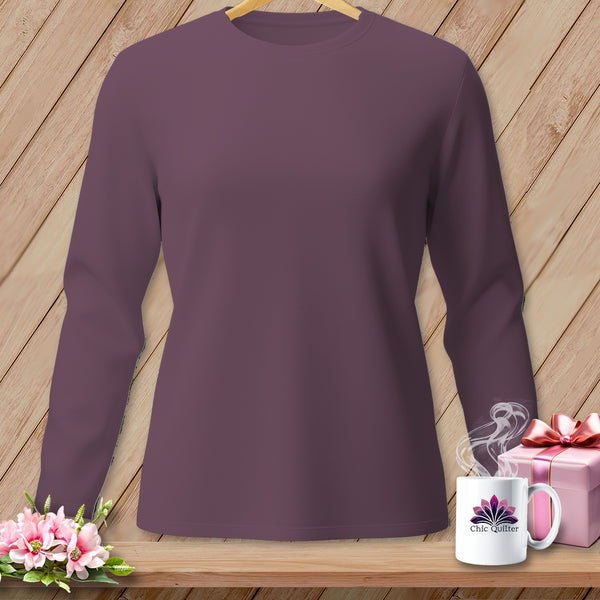 Plum long-sleeve shirt hanging on a wooden background with flowers and gift.