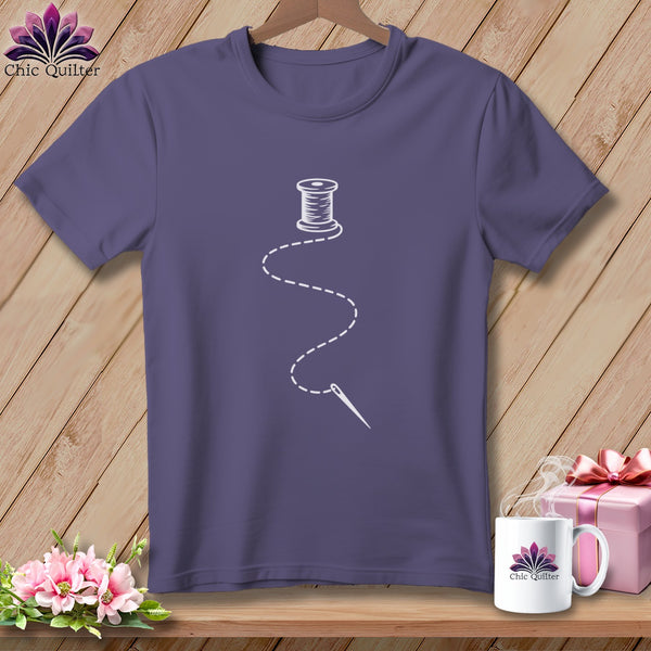 Purple t-shirt with a white spool of thread and needle graphic.