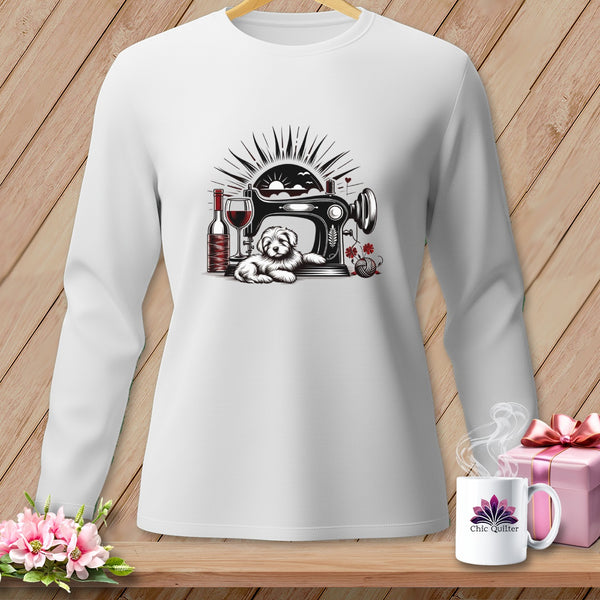 White long-sleeve shirt with a graphic of a dog by a sewing machine, wine, and yarn.