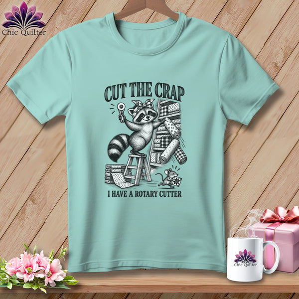 Raccoon with rotary cutter and mouse on stacks of fabric, "Cut the Crap I Have a Rotary Cutter."