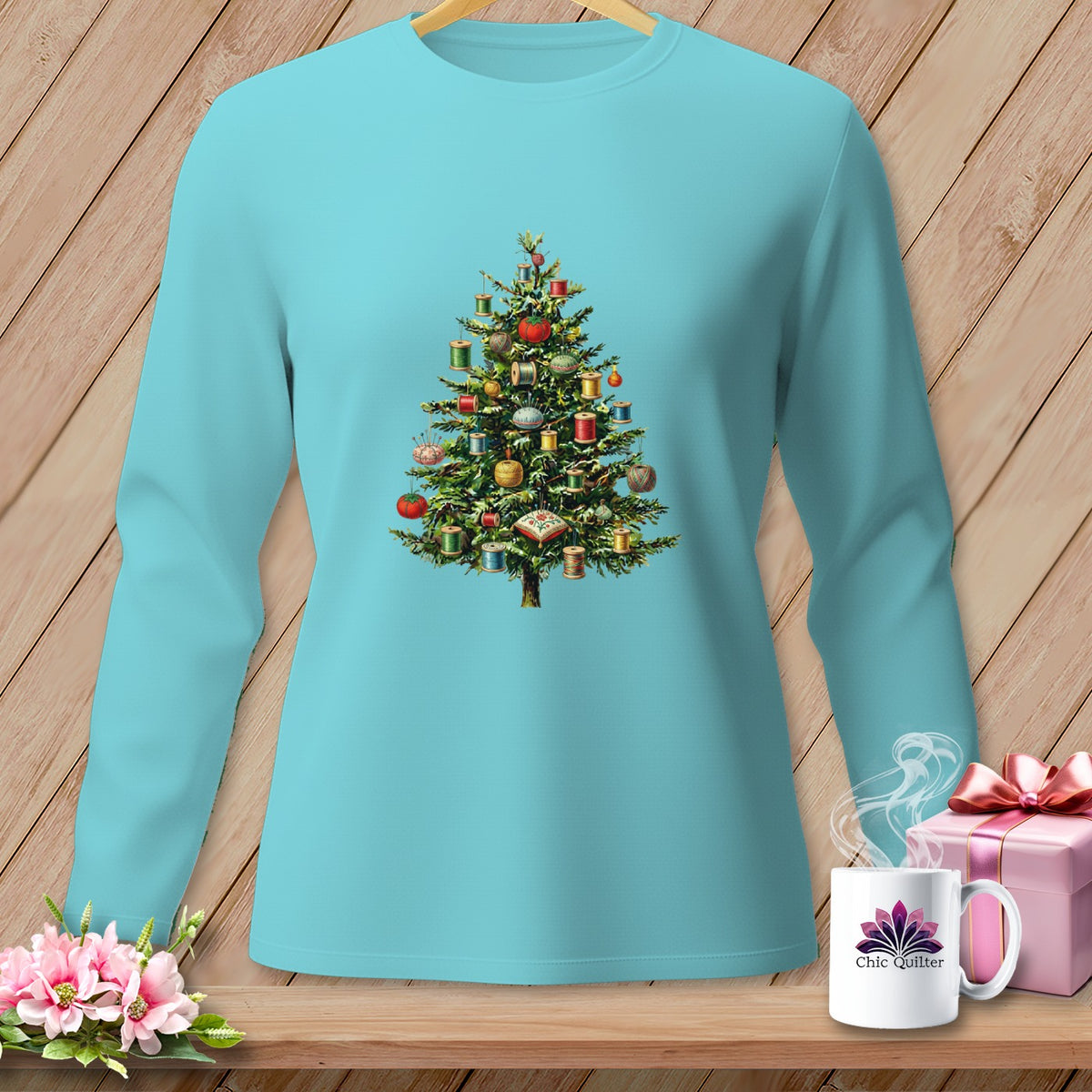 Teal long-sleeve shirt with a Christmas tree adorned with spools of thread.