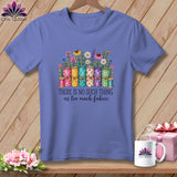 Blue t-shirt featuring a graphic of fabric rolls, flowers, and the text There Is No Such Thing As Too Much Fabric.