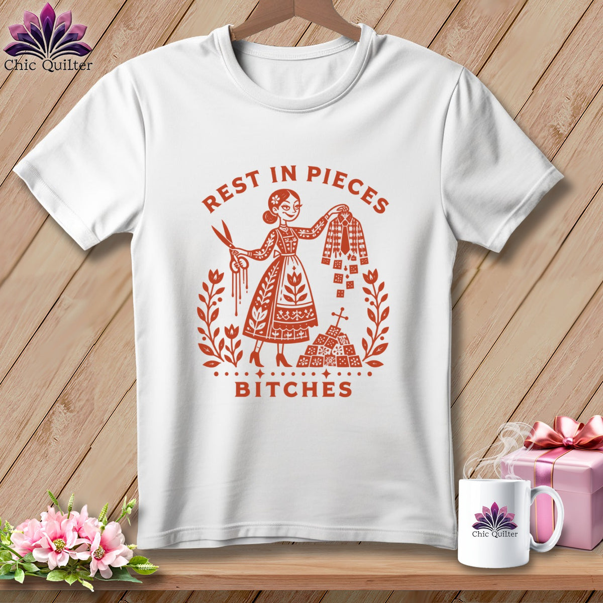 White t-shirt graphic with woman holding scissors, fabric, and text "REST IN PIECES BITCHES".