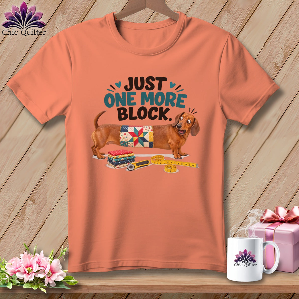 Dachshund wearing a quilt block with text "JUST ONE MORE BLOCK."