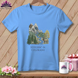 Light blue t-shirt with mountain landscape, elk, and text 