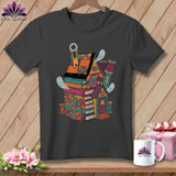 Quilted house with books, buttons, ghosts, and sewing supplies graphic on t-shirt.
