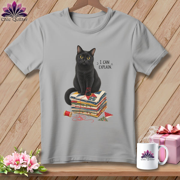 Gray t-shirt with a black cat sitting on a stack of quilts, saying "I CAN EXPLAIN."