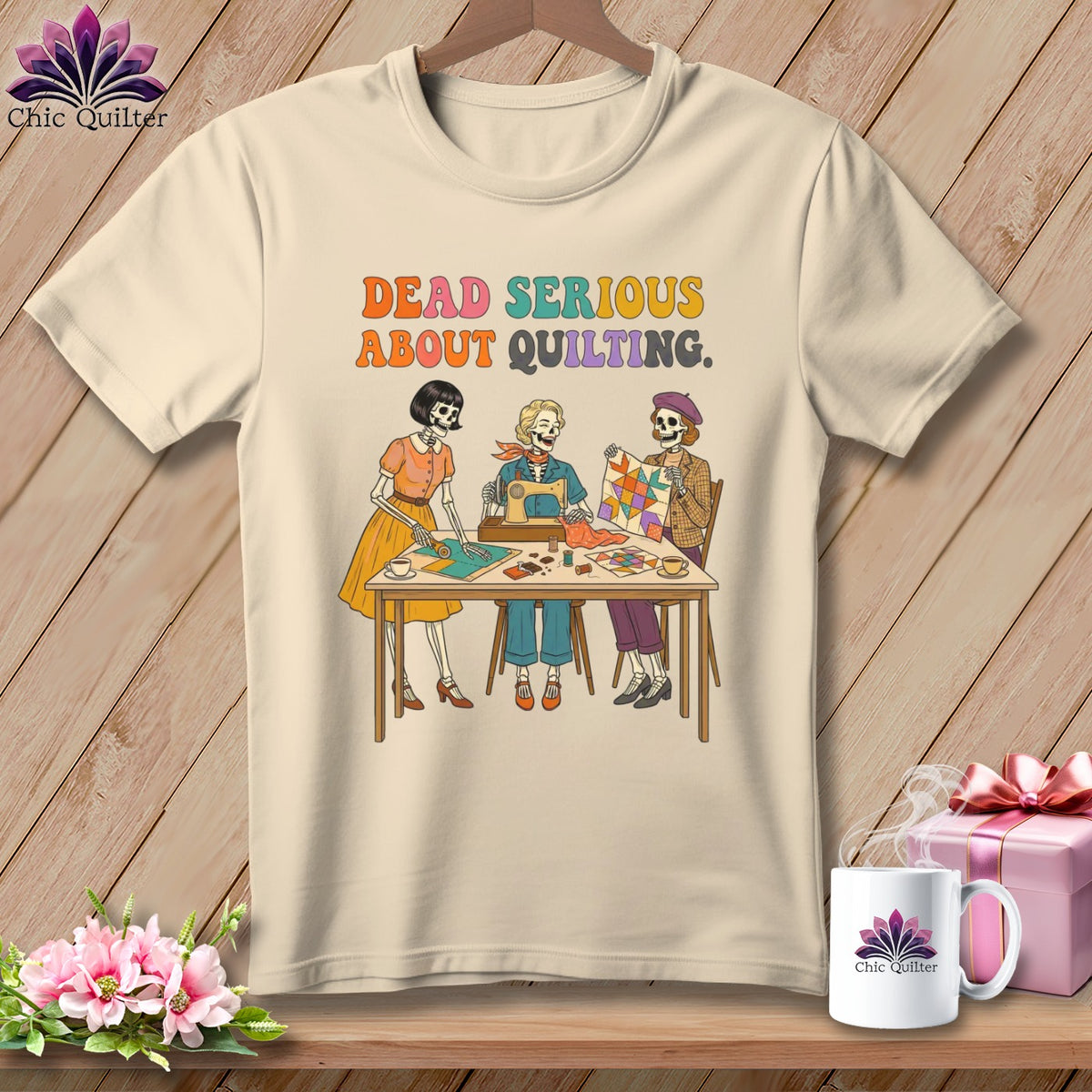 T-shirt graphic with three skeletons sewing and quilting, reading "Dead Serious About Quilting."