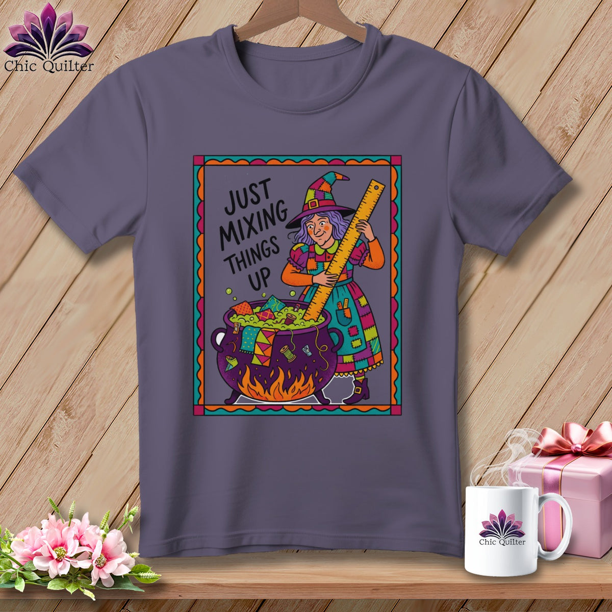 Purple t-shirt with a witch stirring a cauldron, reads "Just Mixing Things Up".
