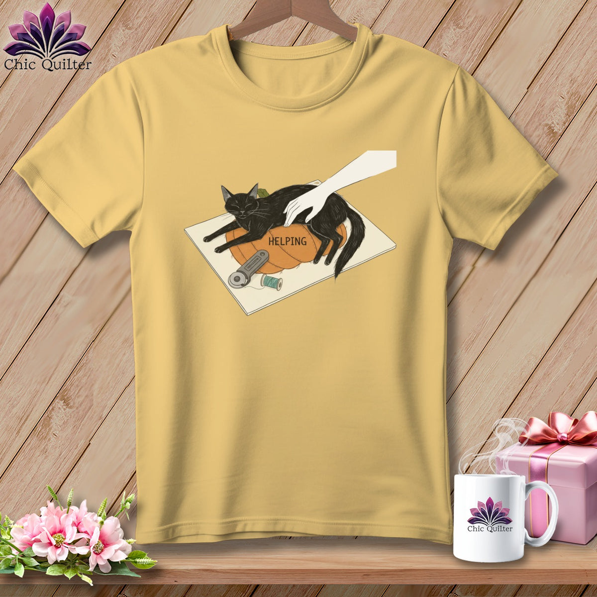 Yellow t-shirt with a black cat on a pumpkin with the word "HELPING" and sewing supplies.