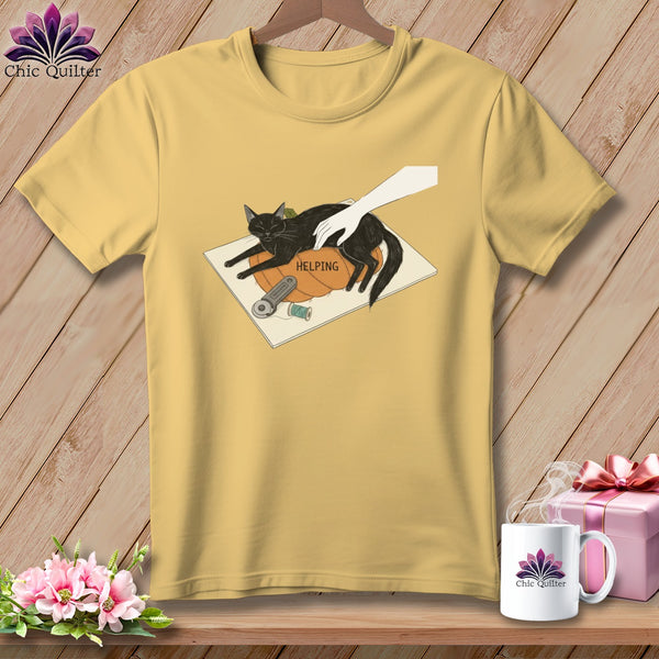 Yellow t-shirt with a black cat on a pumpkin with the word "HELPING" and sewing supplies.