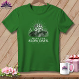 Green t-shirt with white graphic featuring a sun and quilted landscape, text 