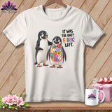Two penguins on a t-shirt, one wearing a colorful patchwork bib, with text.