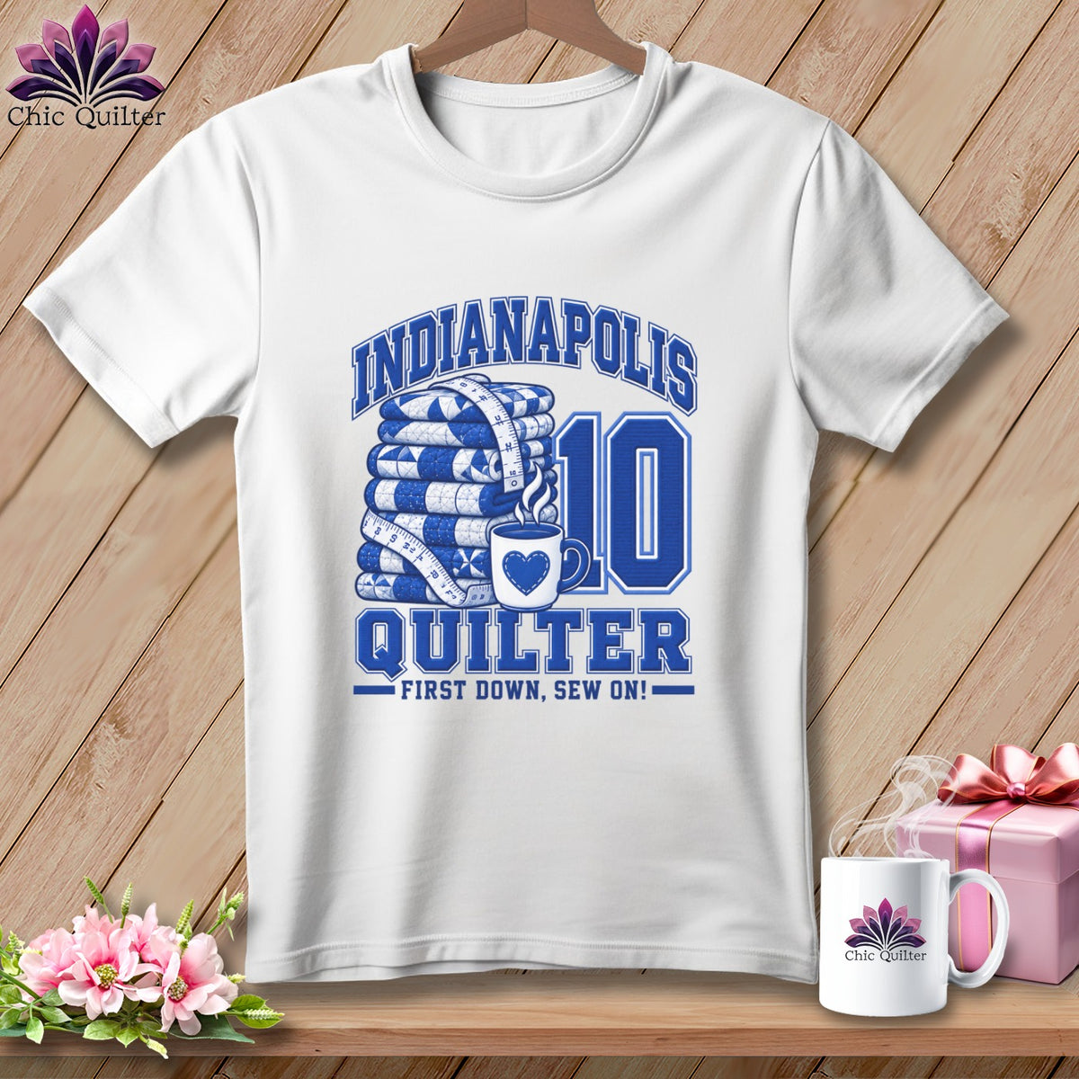 A white t-shirt features blue text reading Indianapolis Quilter, First Down, Sew On, alongside stacked quilts, a coffee mug, and the number ten.