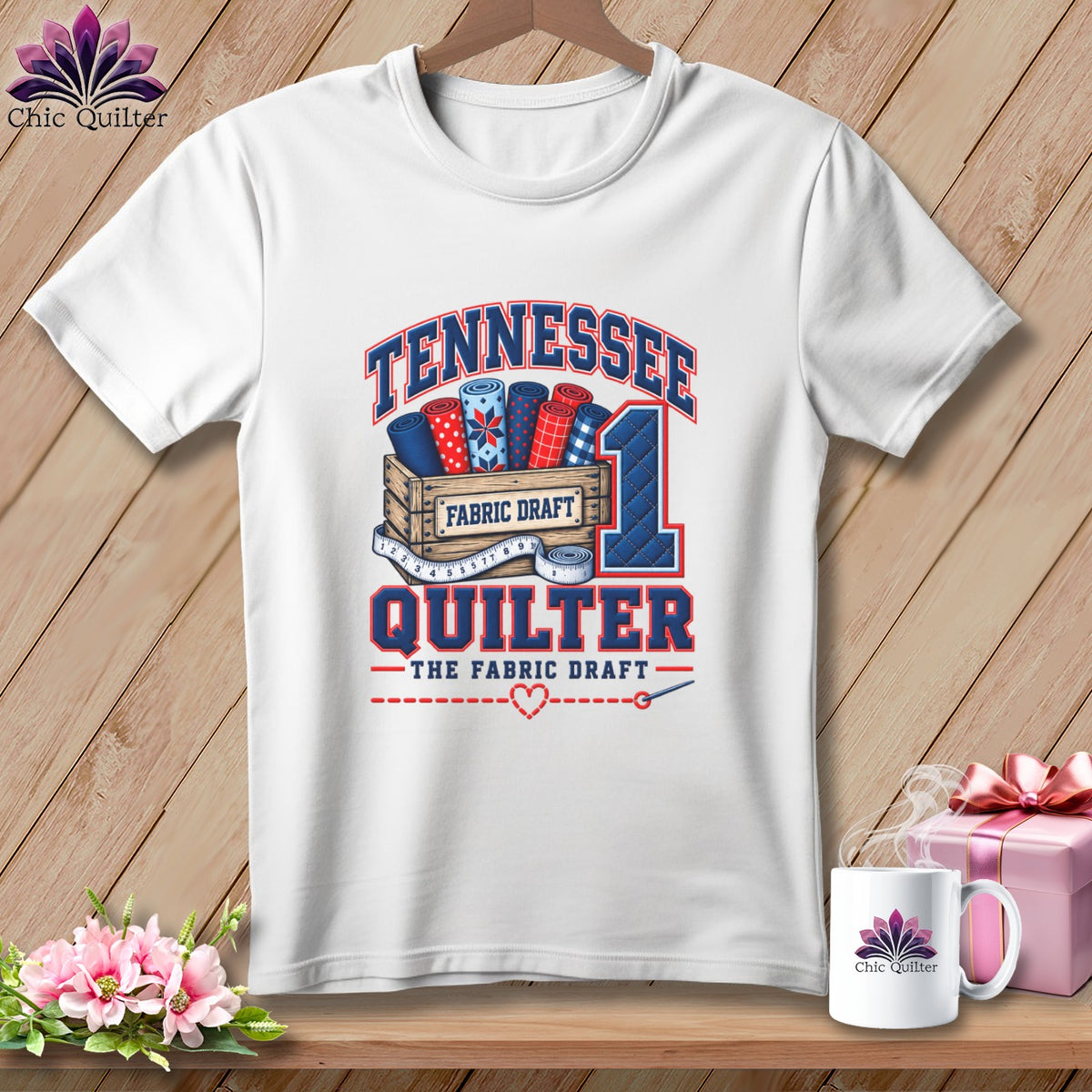 White t-shirt with a blue and red graphic featuring the text Tennessee Quilter and fabric rolls.