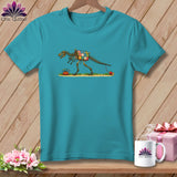 Teal t-shirt featuring a graphic of a skeletal dinosaur wearing a patchwork quilt and pulling thread.