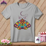Grey t-shirt with a patchwork moth design featuring sewing notions and a crescent moon.