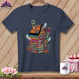 Dark t-shirt with a colorful quilt-themed house on books, featuring ghosts and sewing notions.
