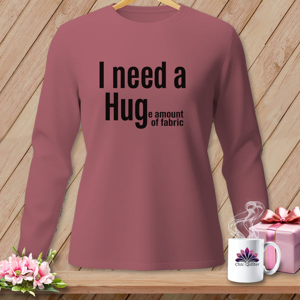 Rose long-sleeve shirt with black text: "I need a Hug e amount of fabric."
