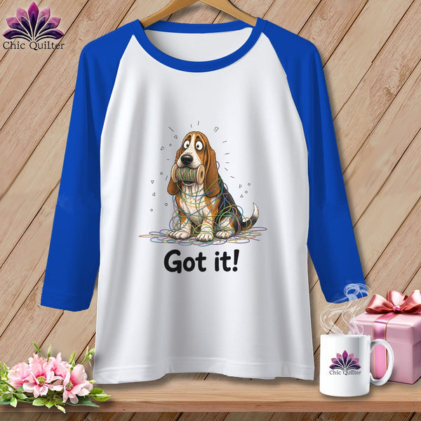 White raglan shirt with a basset hound tangled in colorful yarn and the text "Got it!".