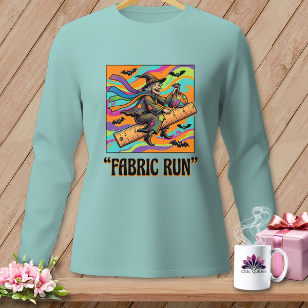 Light blue long-sleeve shirt with a graphic of a witch flying on a ruler, text reads "FABRIC RUN".