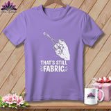 Purple t-shirt with a hand holding scissors cutting a small piece of fabric and the text 