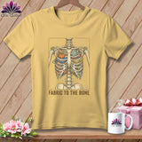 Yellow t-shirt with a skeleton ribcage filled with fabric and a pumpkin pin cushion. Text reads: FABRIC TO THE BONE.