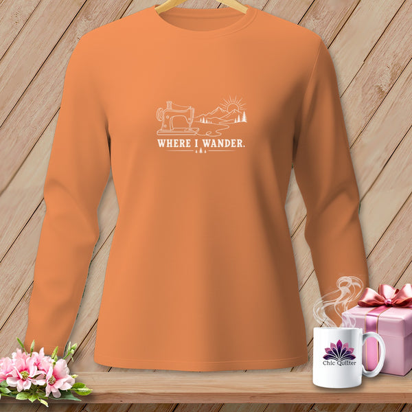 Orange long-sleeve shirt with white graphic of sewing machine and mountains, text "WHERE I WANDER."