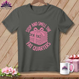 A dark gray t-shirt featuring a pink graphic of folded fabric with a bow and text reading stop and smell the fat quarters.