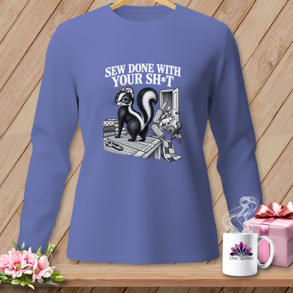 T-shirt graphic of skunk on sewing table with text "Sew Done With Your Sh*t."