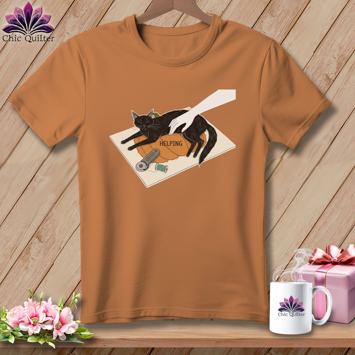 Black cat on pumpkin with sewing notions and text "HELPING".