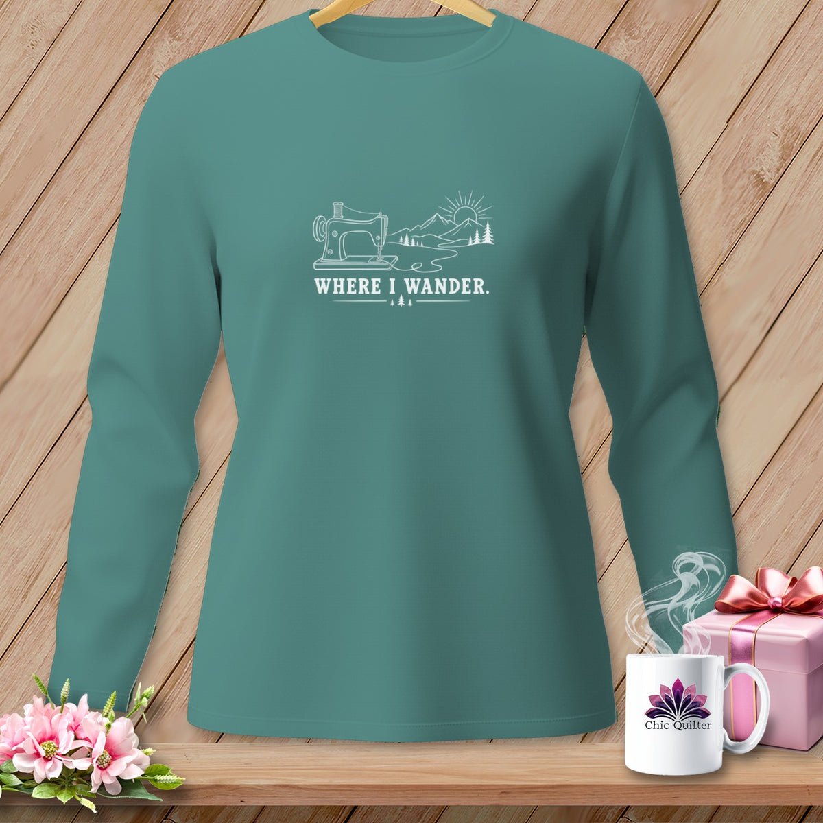 Teal long-sleeve shirt with sewing machine, mountains, and text "WHERE I WANDER."