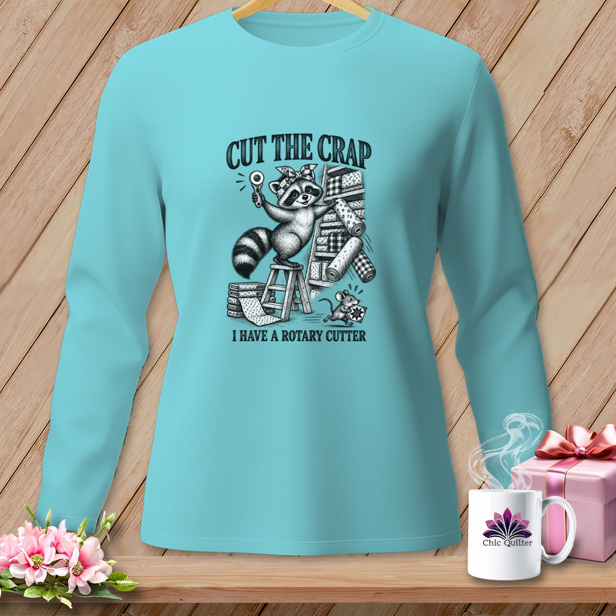 Aqua long sleeve shirt with raccoon graphic and "Cut the Crap I Have a Rotary Cutter" text.