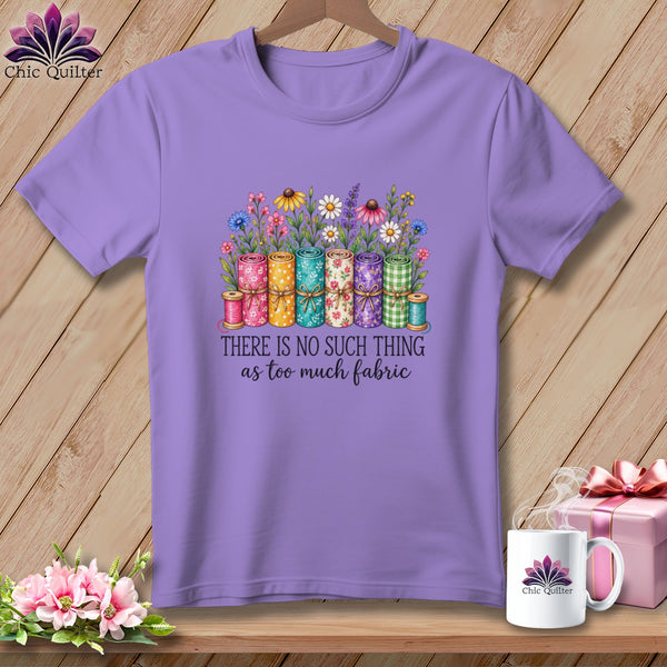 A purple t-shirt features a graphic of rolled fabric, flowers, and the text "There is no such thing as too much fabric."
