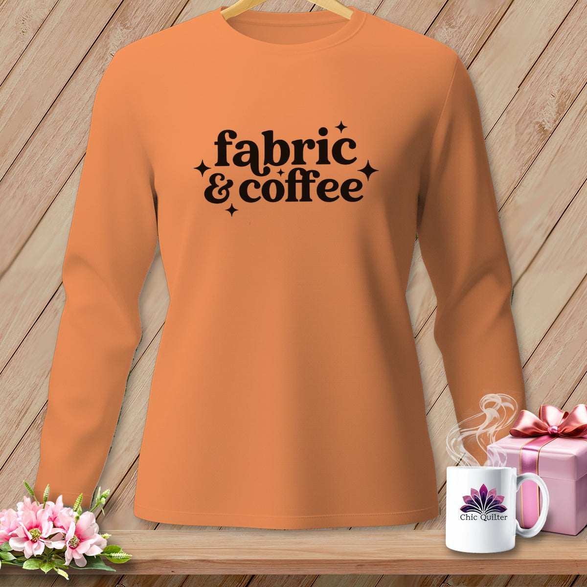 Orange long-sleeve shirt with "fabric & coffee" text and sparkling accents.