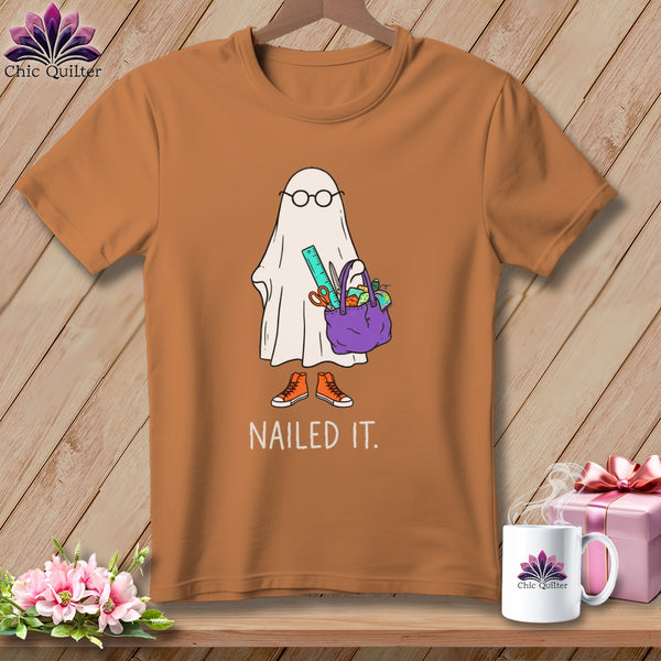 Orange t-shirt with ghost design, glasses, craft bag, and "NAILED IT." text.