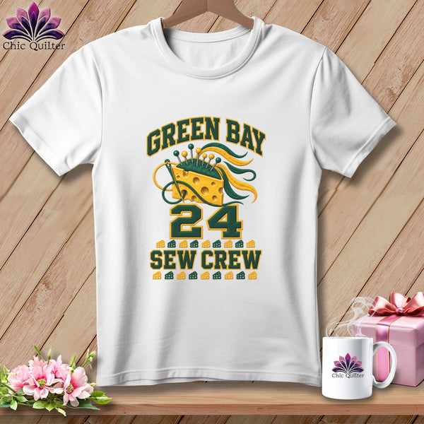A white crewneck t-shirt featuring a green and yellow "Green Bay Sew Crew 24" design with a cheese wedge pin cushion.