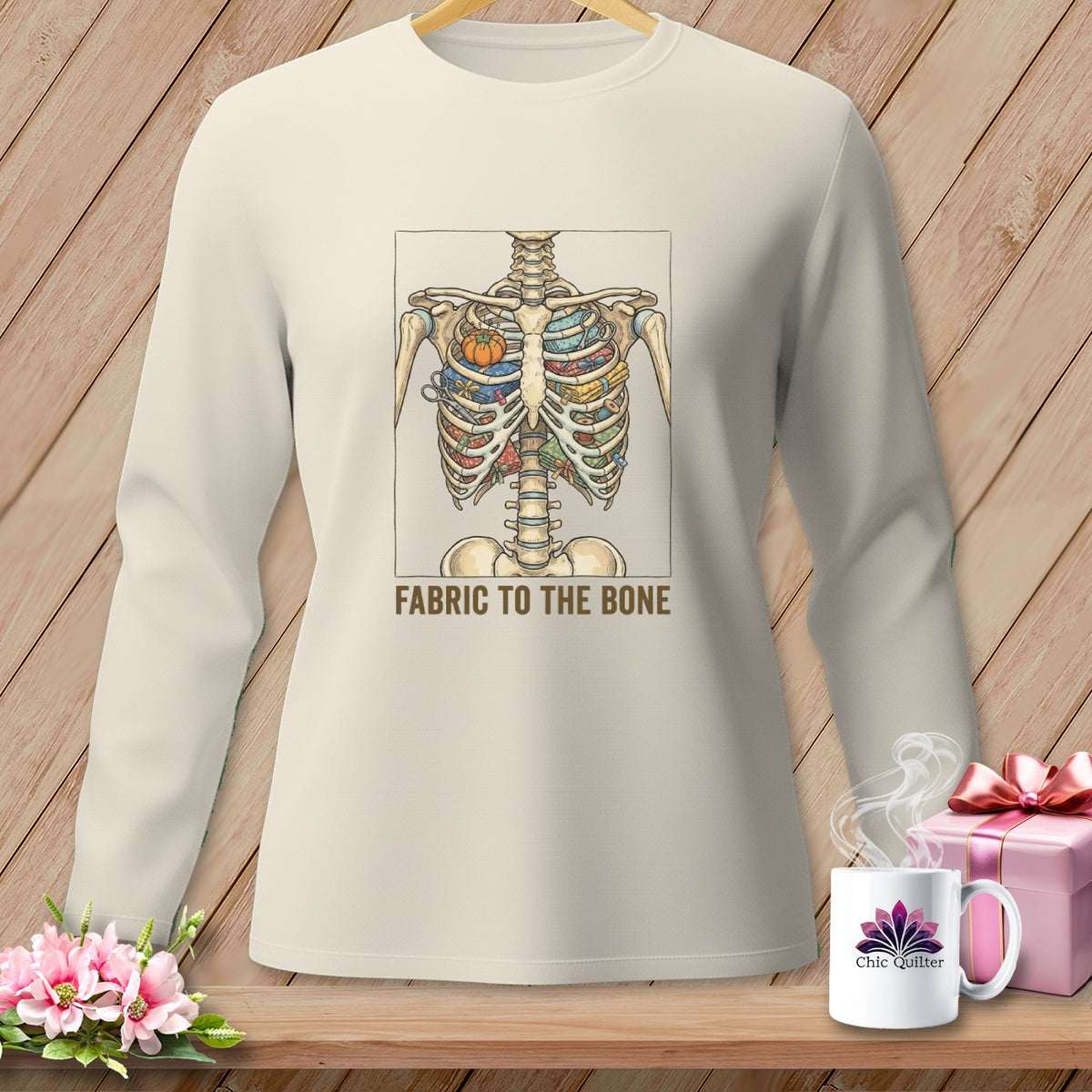 Cream long-sleeve shirt with a skeleton chest filled with fabric scraps and text "FABRIC TO THE BONE".