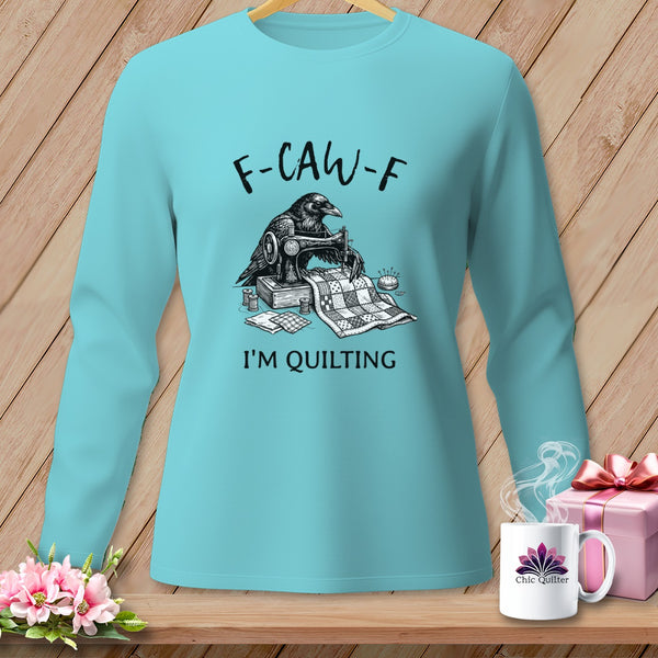 Turquoise long-sleeve shirt with a raven sewing a quilt, text reads "F-CAW-F I'M QUILTING".