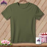 Olive green t-shirt on a wooden background with flowers and a mug.