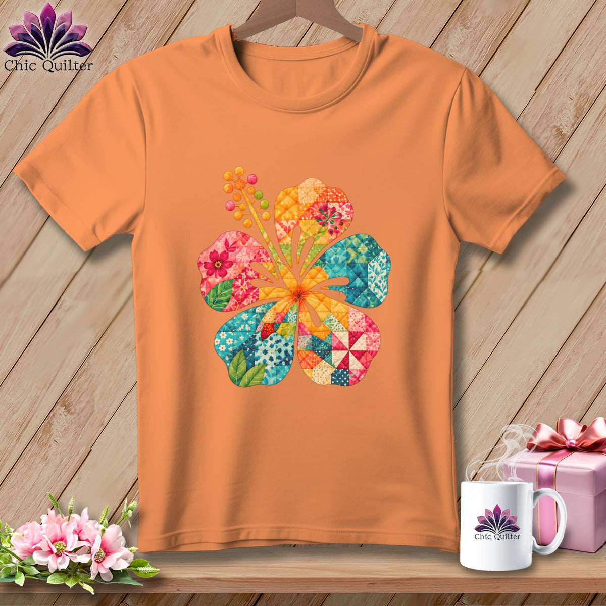Orange short-sleeved t-shirt hanging on a wooden wall, featuring a colorful patchwork hibiscus flower graphic.