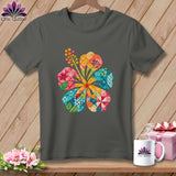 Charcoal gray t-shirt featuring a large, colorful hibiscus flower made of patchwork patterns, hanging on a wooden background.