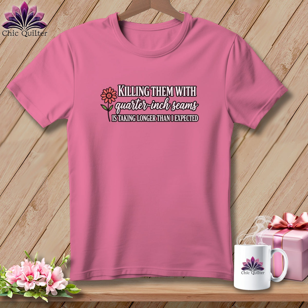 Pink t-shirt on a wooden hanger with the text Killing them with quarter inch seams is taking longer than I expected.