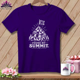 Purple t-shirt with a graphic of stacked quilts on a mountain peak with a flag.