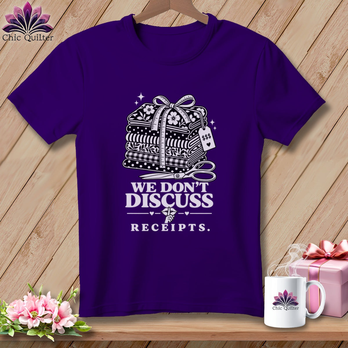 Purple t-shirt with a graphic of stacked fabric, scissors, and the text "WE DON'T DISCUSS RECEIPTS."